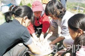 손수건의 불순물을 없애기 위해 콩즙에 손수건을 주무른다. 2005년 6월. 사진 / 박지영 기자