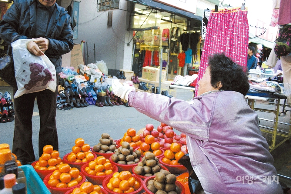 팔려고 쌓아둔 땅콩캐러멜을 한 뭉텅이 쥐어주는 할머니. 2006년 1월. 사진 / 박지영 기자
