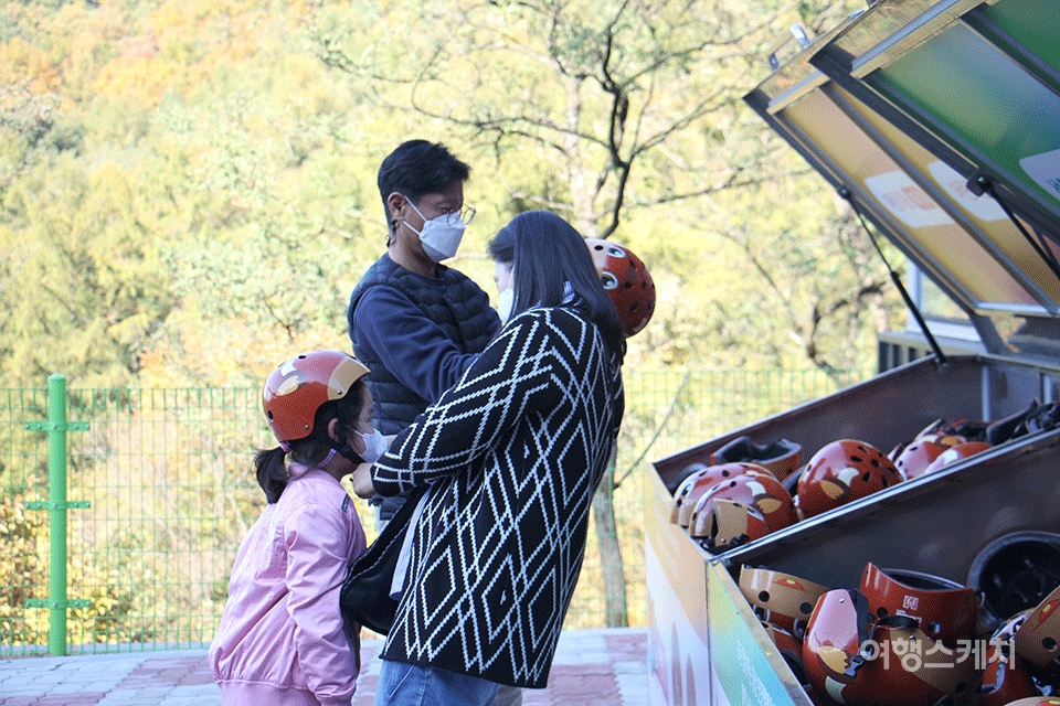 가족 여행자가 루지 체험에 앞서 안전모를 착용하는 모습. 사진 / 조용식 기자​
