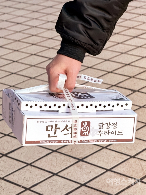 시장을 찾은 사람들 손에는 어김없이 하나씩 만석닭강정 박스가 쥐어져 있다. 사진 / 민다엽 기자