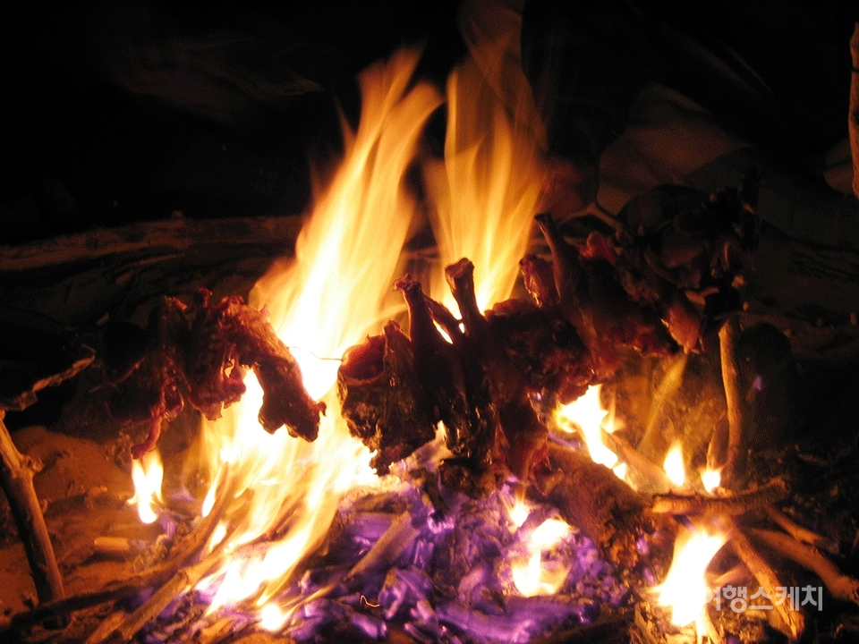 토막 내어 자른 양고기의 일부를 철사줄에 엮어 모닥불에서 지글지글 굽는다. 2004년 8월. 사진 / 이분란 객원기자
