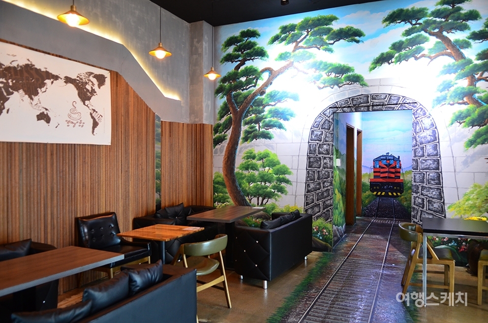 기찻길 모양의 그림으로 장식된 카페 내부. 사진 / 권다현 여행작가