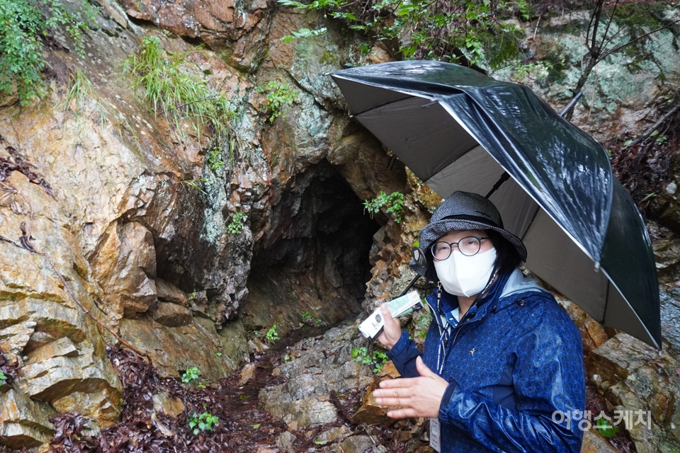 농수로를 만들면서 인공적으로 뚫은 동굴을 설명하고 있는 김진남 해설사. 사진 / 노규엽 기자